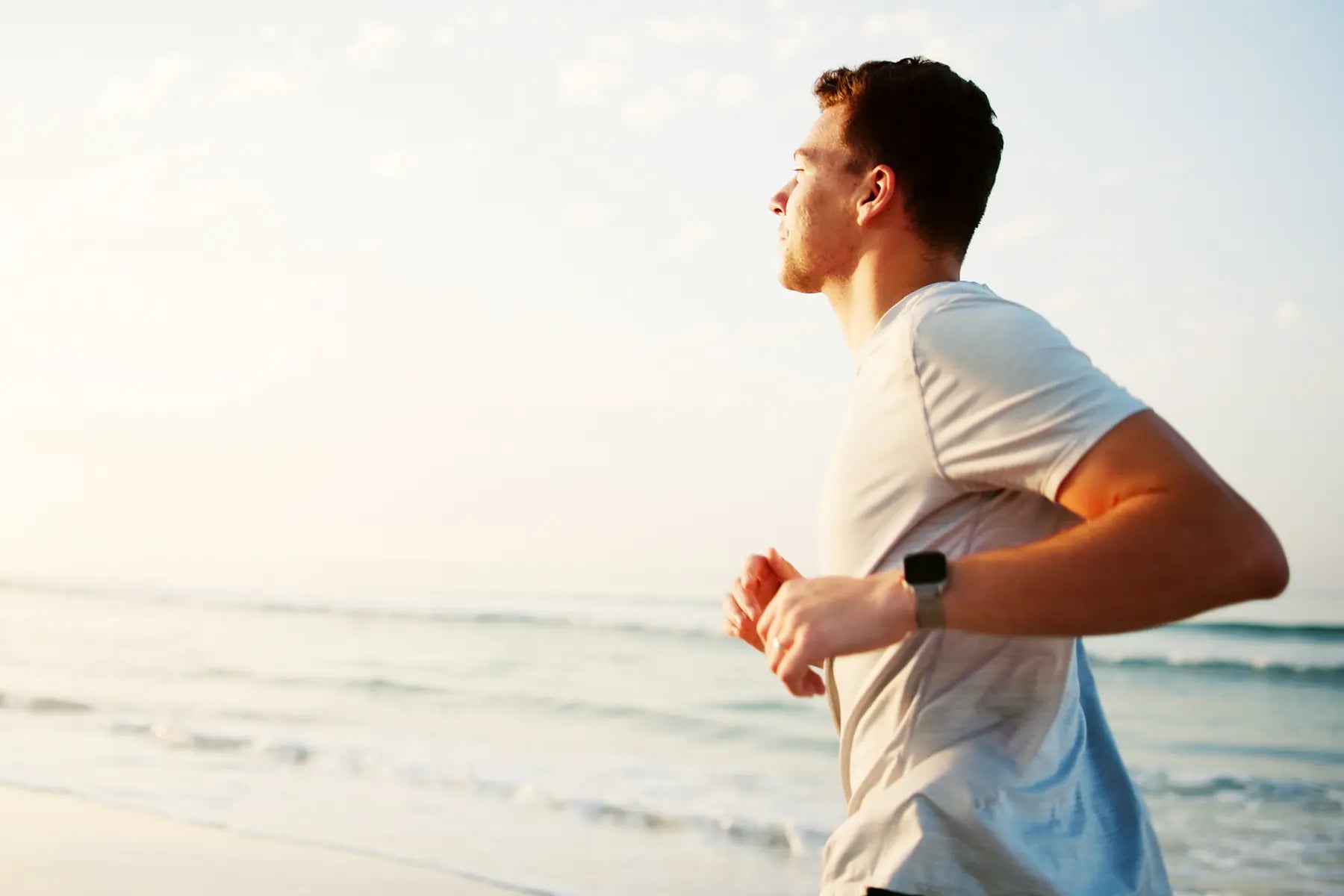 Fitness body scan concept showing a man jogging on the beach to monitor health and body composition progress