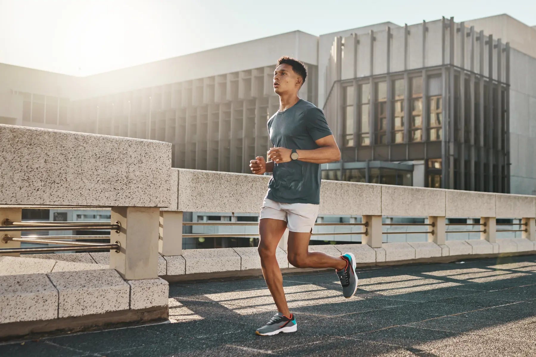 A DEXA scan for fitness assessment supported by man jogging outdoors in athletic gear near modern buildings.