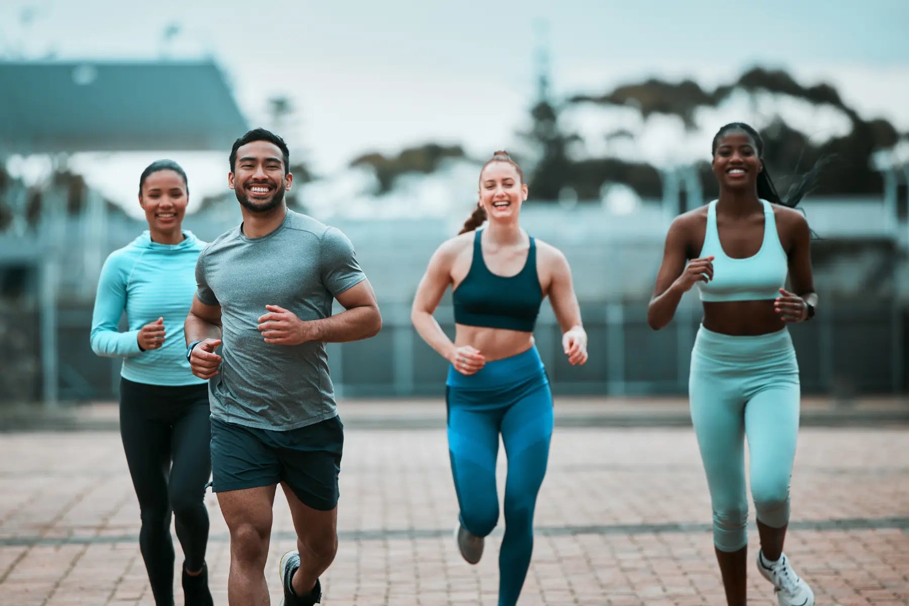 Body composition testing candidates jogging together on an outdoor brick path.