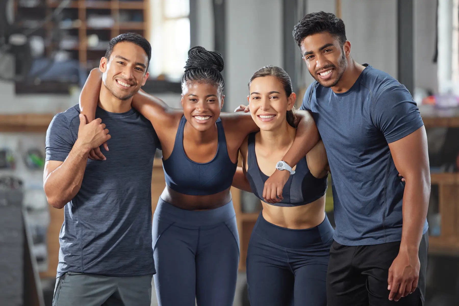 Bone health for women highlighted by a strong group of female and male athletes smiling after training.