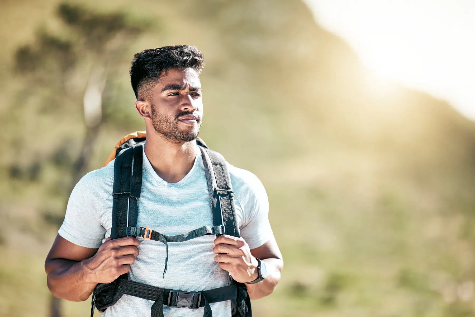 DEXA body composition scan supported by fit man hiking outdoors with backpack in natural sunlight.