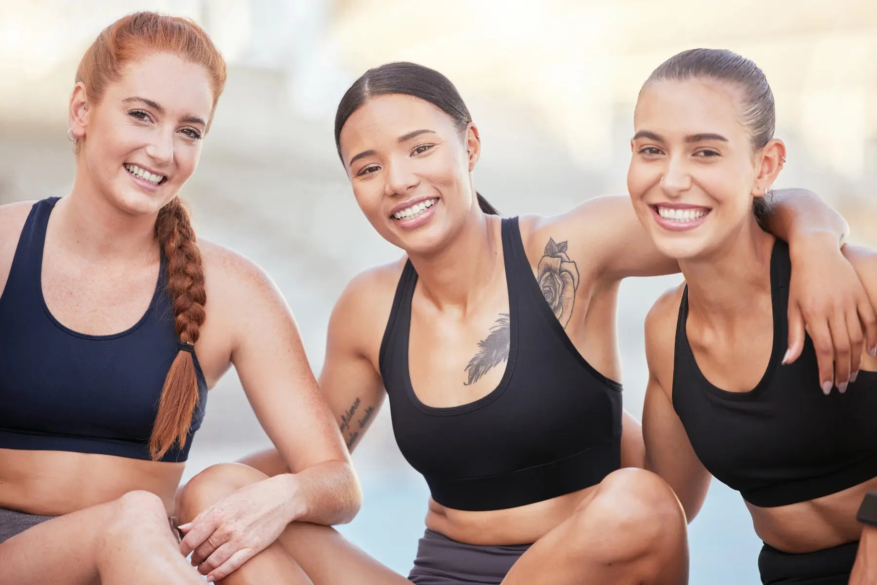 DEXA scan after menopause emphasized by three fit women smiling post-workout, highlighting bone health awareness in active lifestyles.