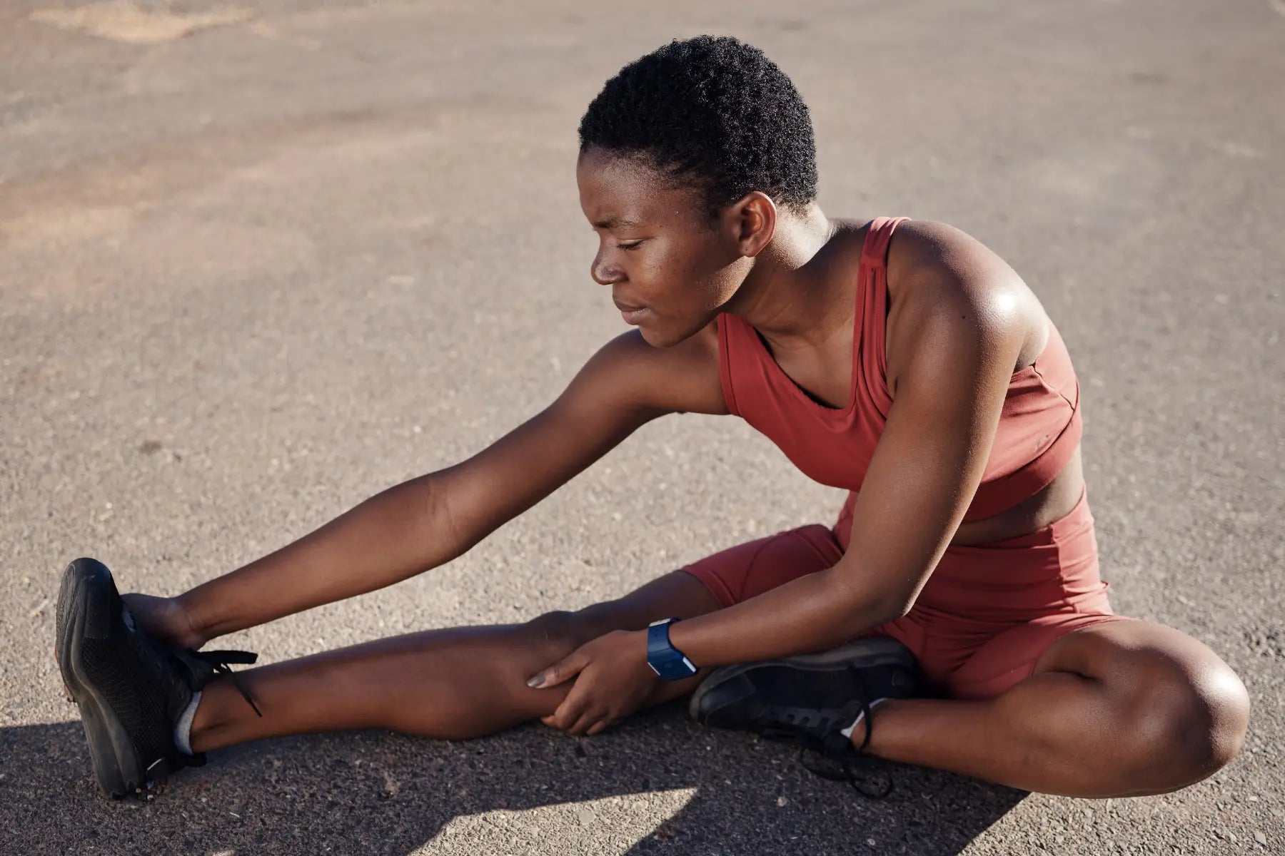 DEXA scan for bone health supported by woman stretching her legs outdoors in athletic wear.