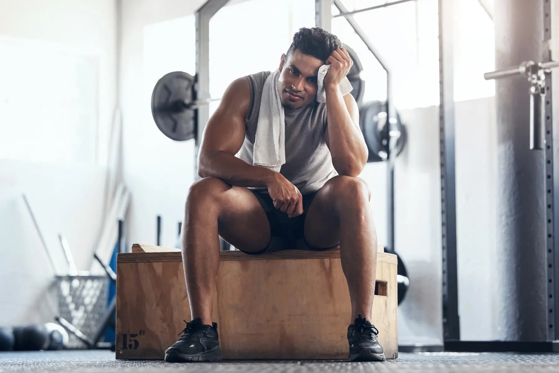 Hydrostatic body composition testing recovery with a muscular man resting on a plyo box after intense exercise.Hydrostatic body composition testing recovery with a muscular man resting on a plyo box after intense exercise.