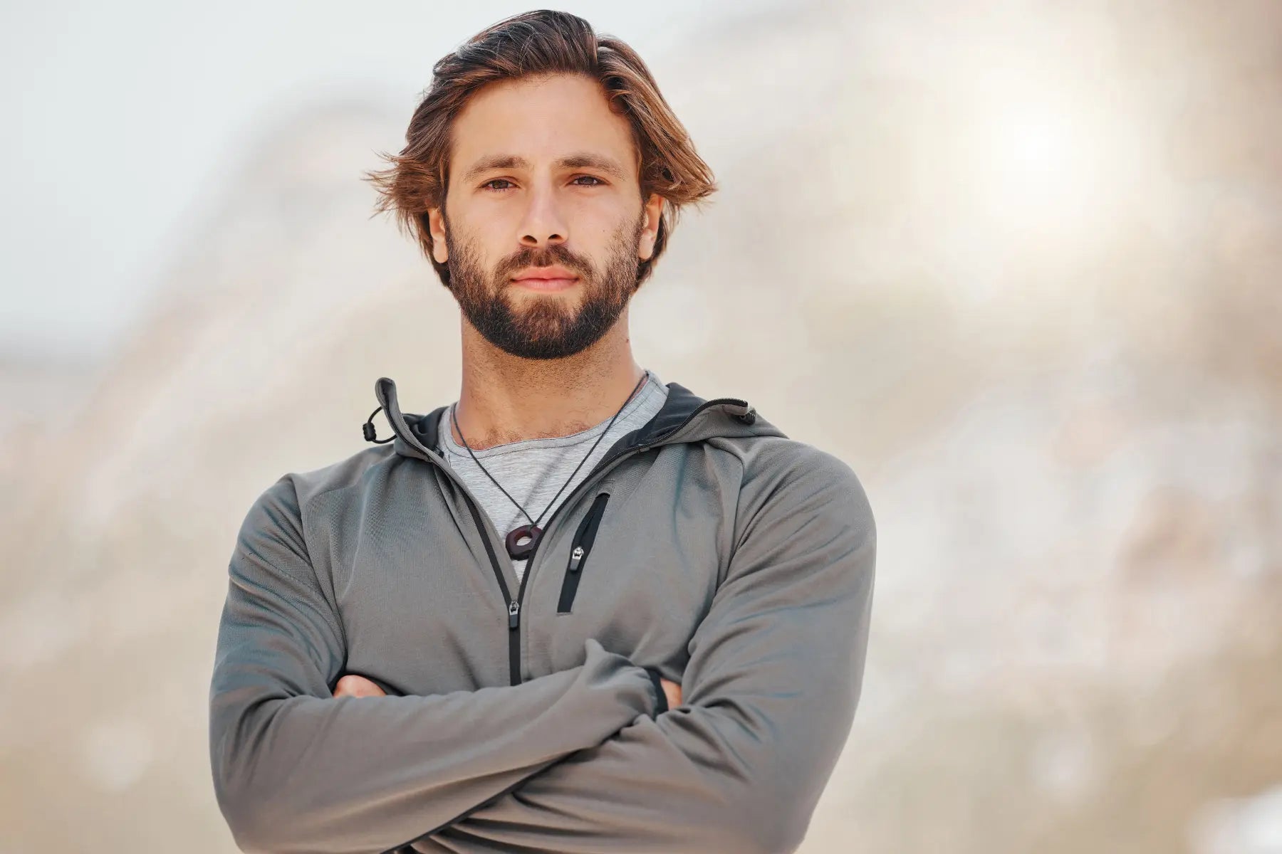 Musculoskeletal scans support strength training for a confident man standing outdoors with arms crossed.
