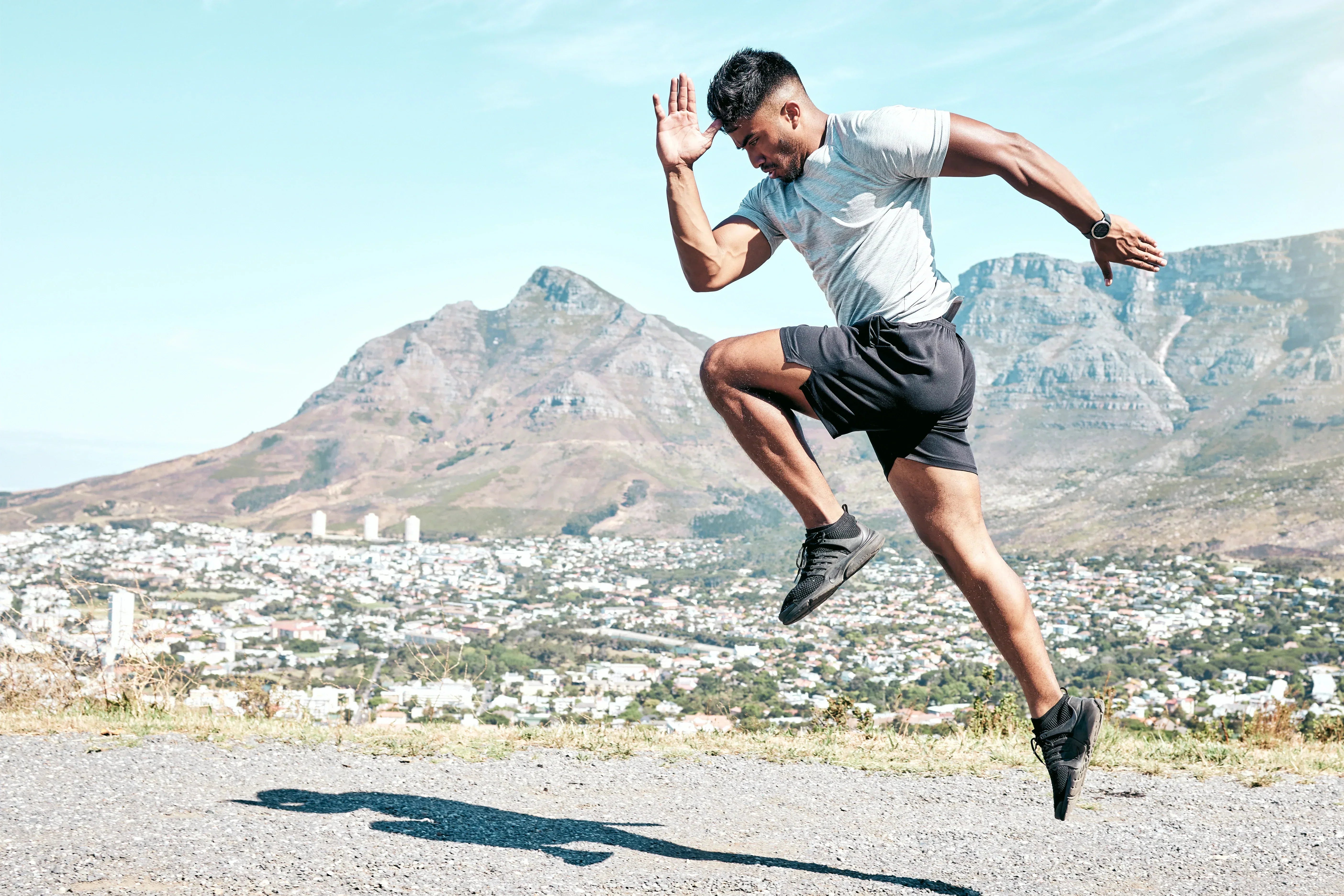 PHY scan technology supports athletic performance with man sprinting outdoors against scenic mountain backdrop.