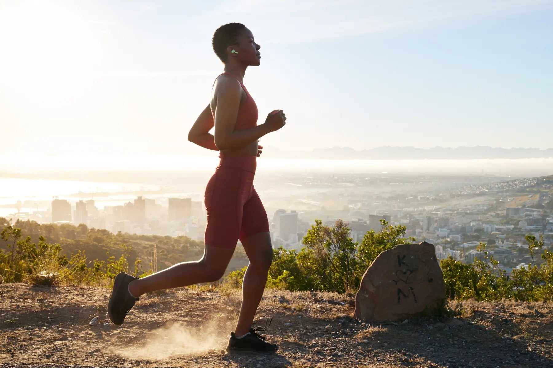 VO2 max testing concept with a woman running uphill at sunrise to assess aerobic fitness.