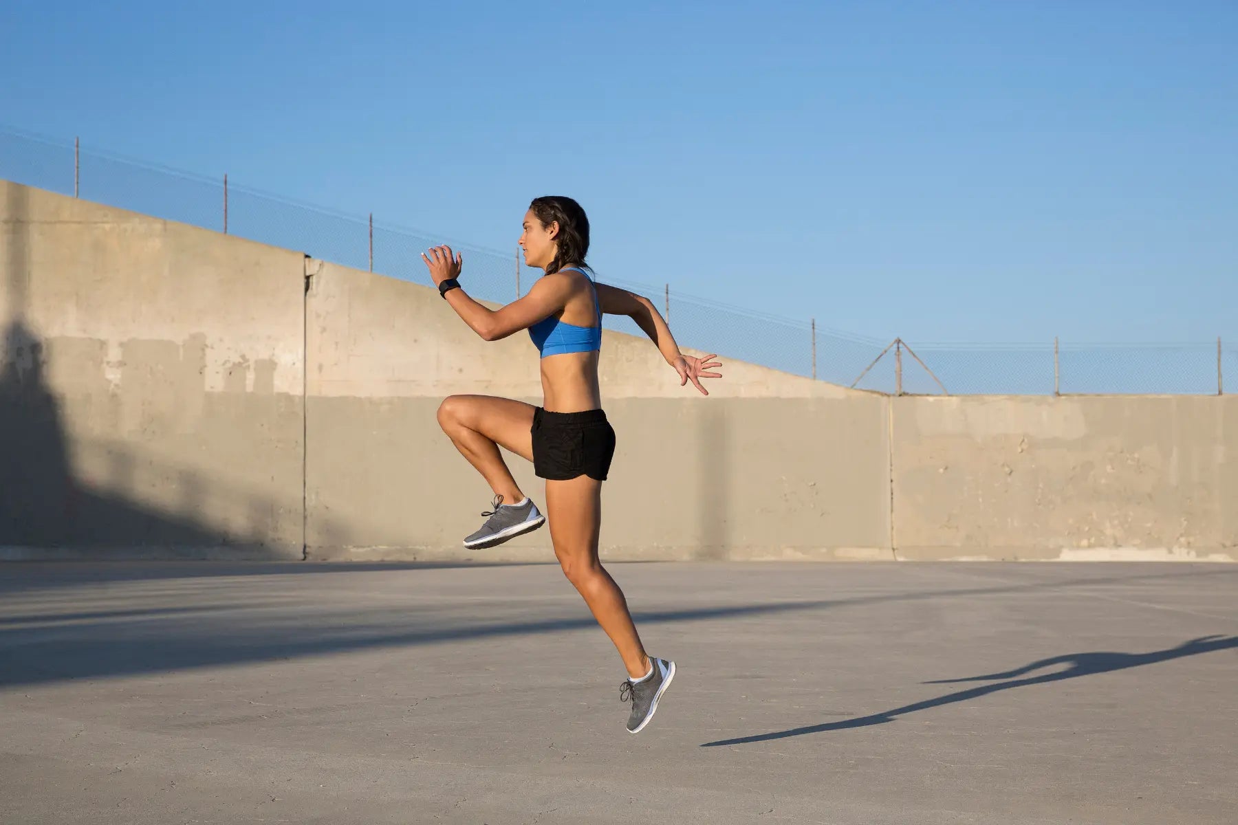 VO2 max weight loss training with a woman performing high-intensity cardio outdoors to burn fat.