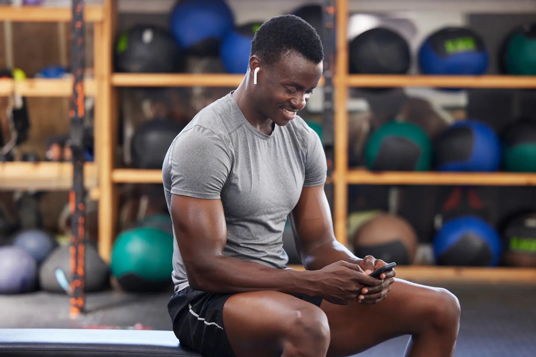 Visceral fat scan tracking by a muscular man reviewing workout data on his phone in the gym.