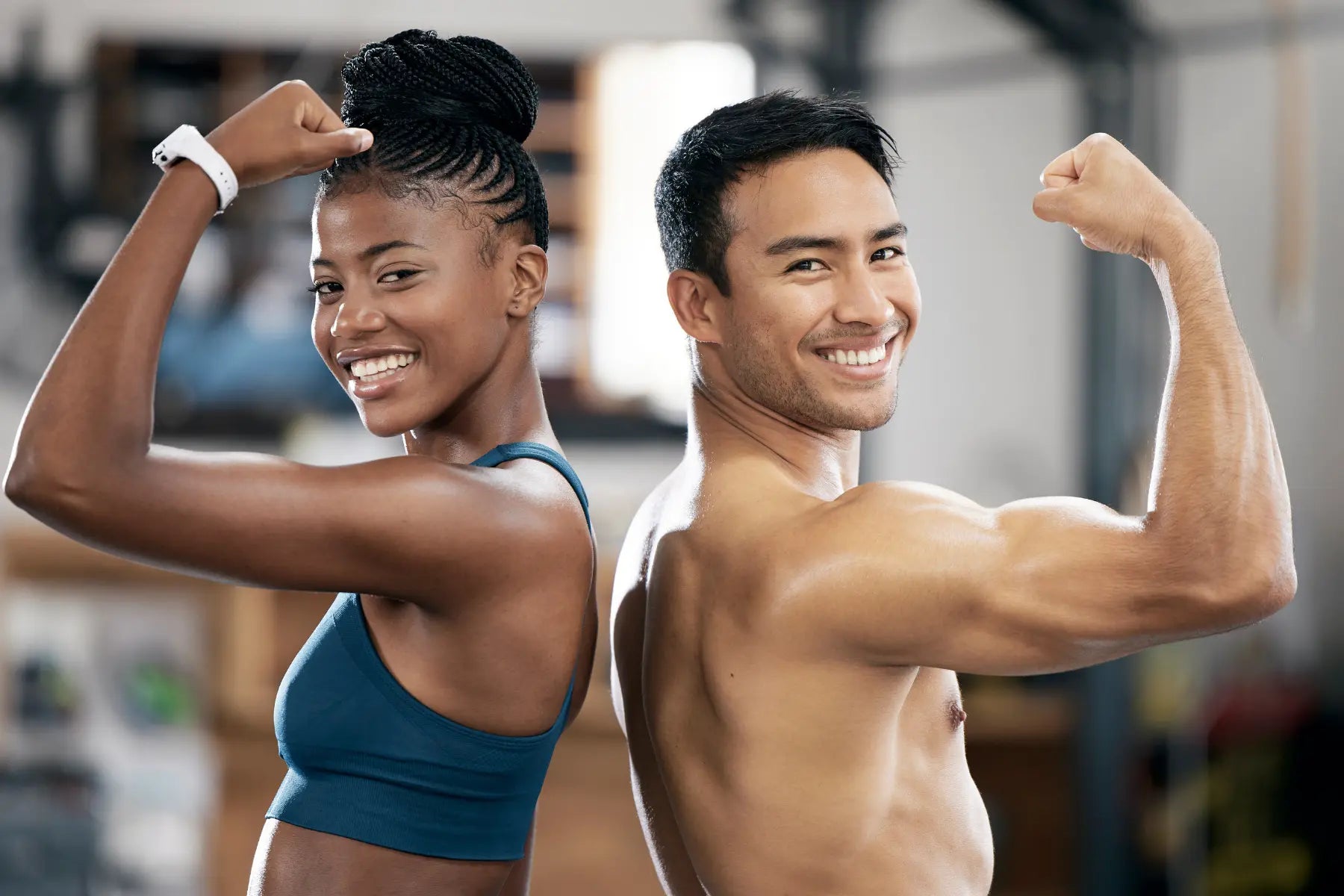Weight loss results on fit man and woman smiling and flexing their biceps back-to-back in a gym setting.