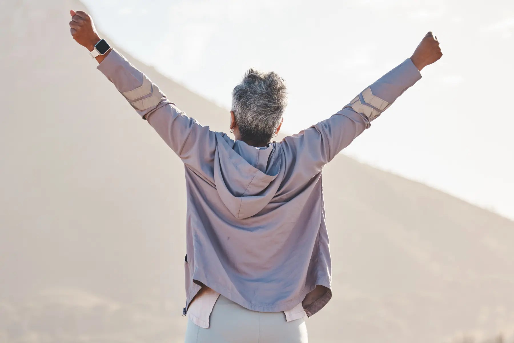 Whole body scan aligns with healthy aging, as an older adult celebrates outdoors with arms raised.