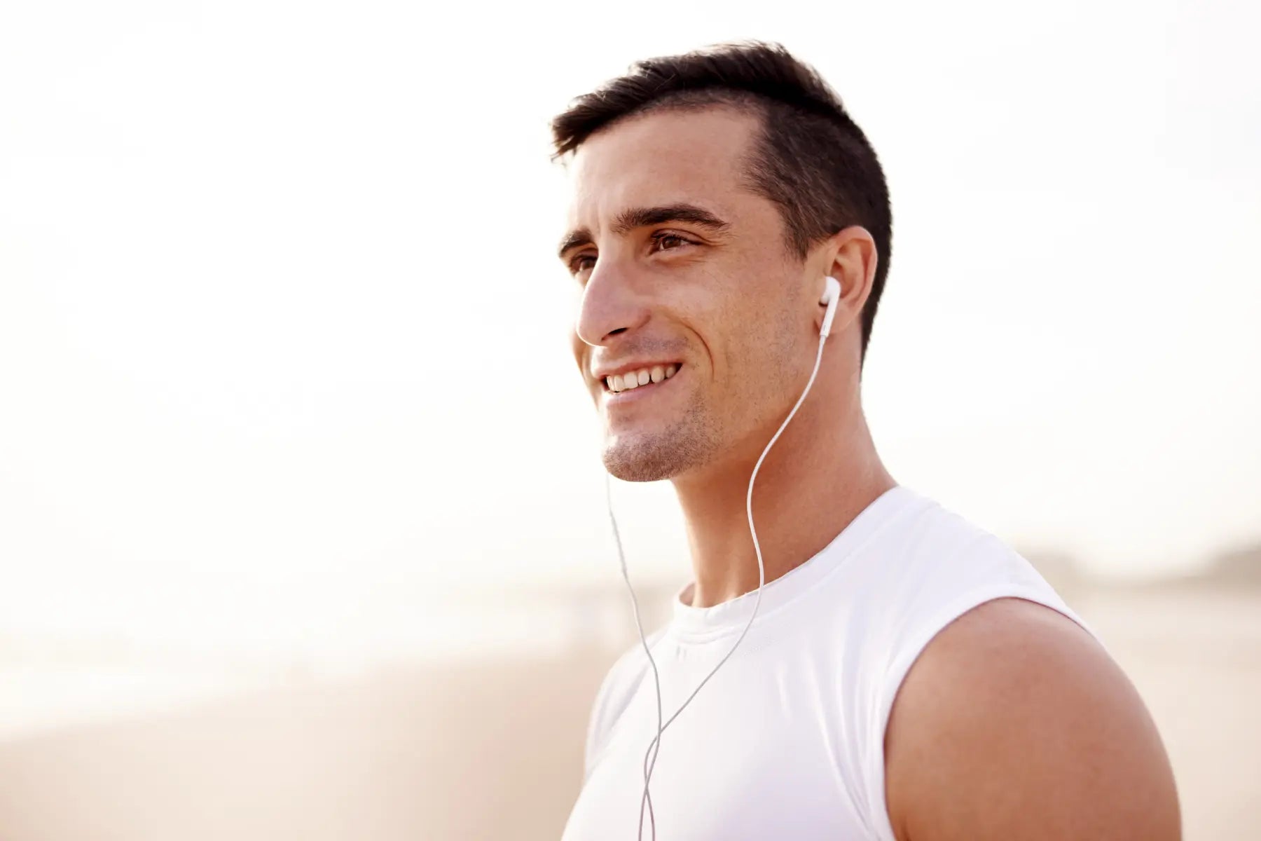 Bone density health supported by a smiling man wearing earphones outdoors after completing his workout