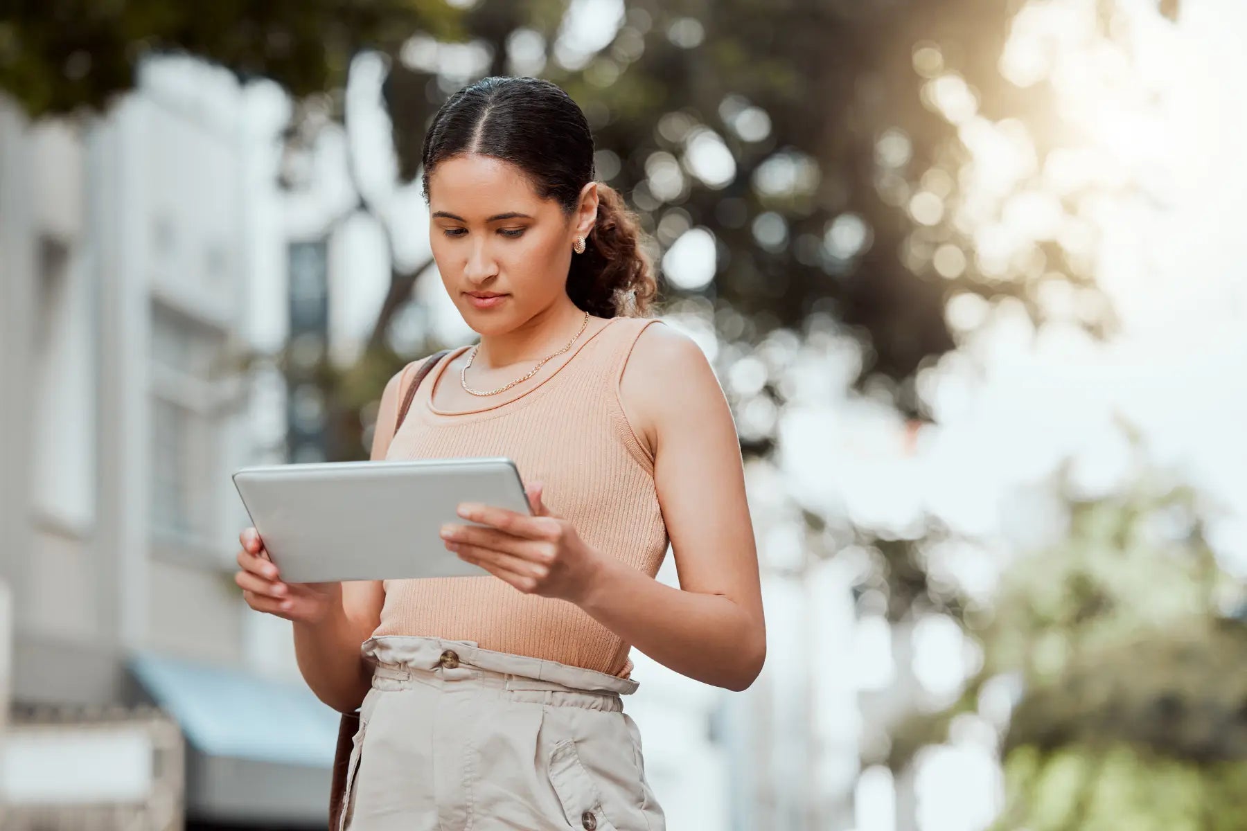 Bone density in women monitored through digital tools as a young woman reviews health data on a tablet outdoors.