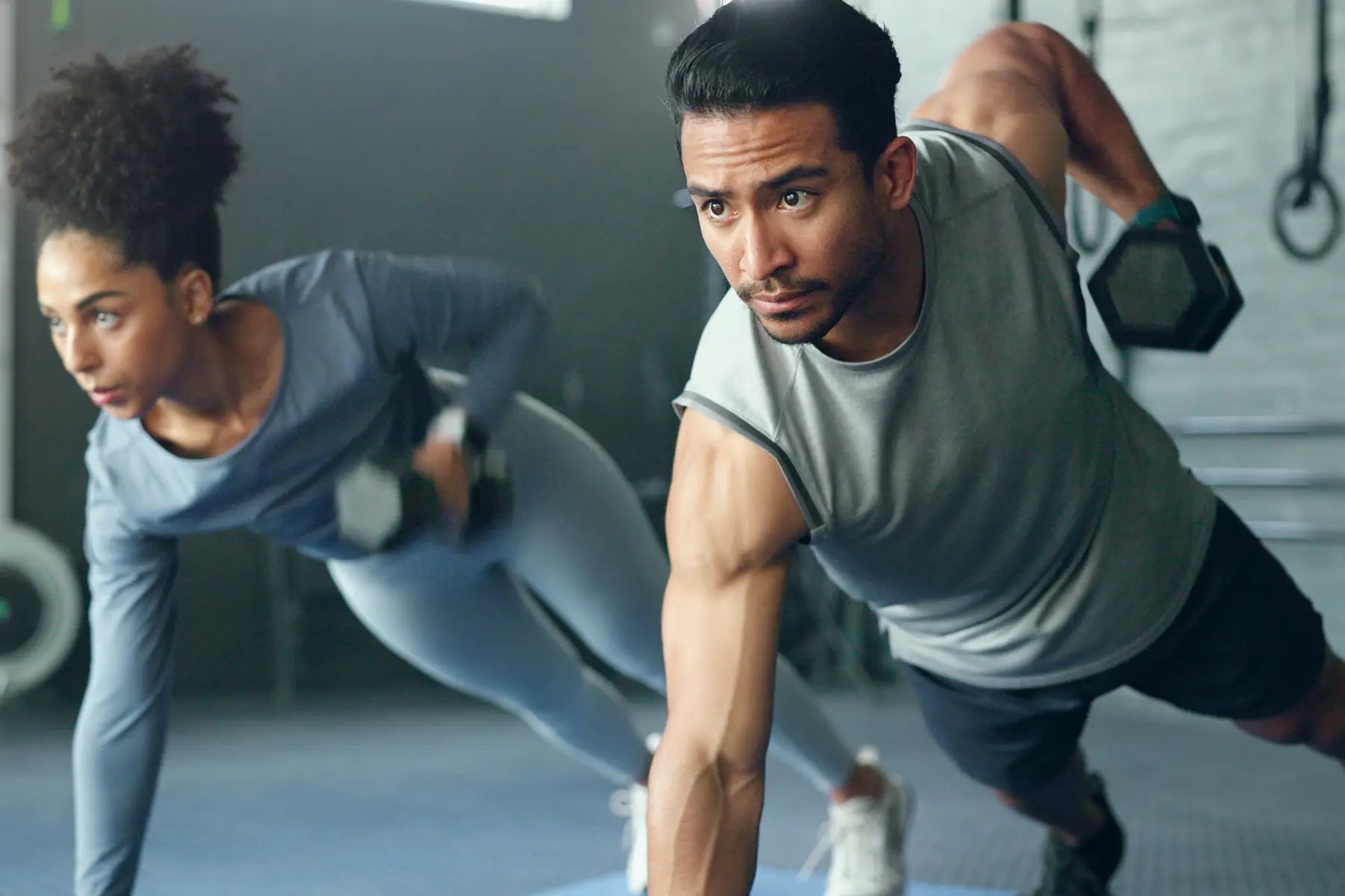 Bone mineral density test relevance shown by man and woman doing weighted planks to strengthen bones and muscles.