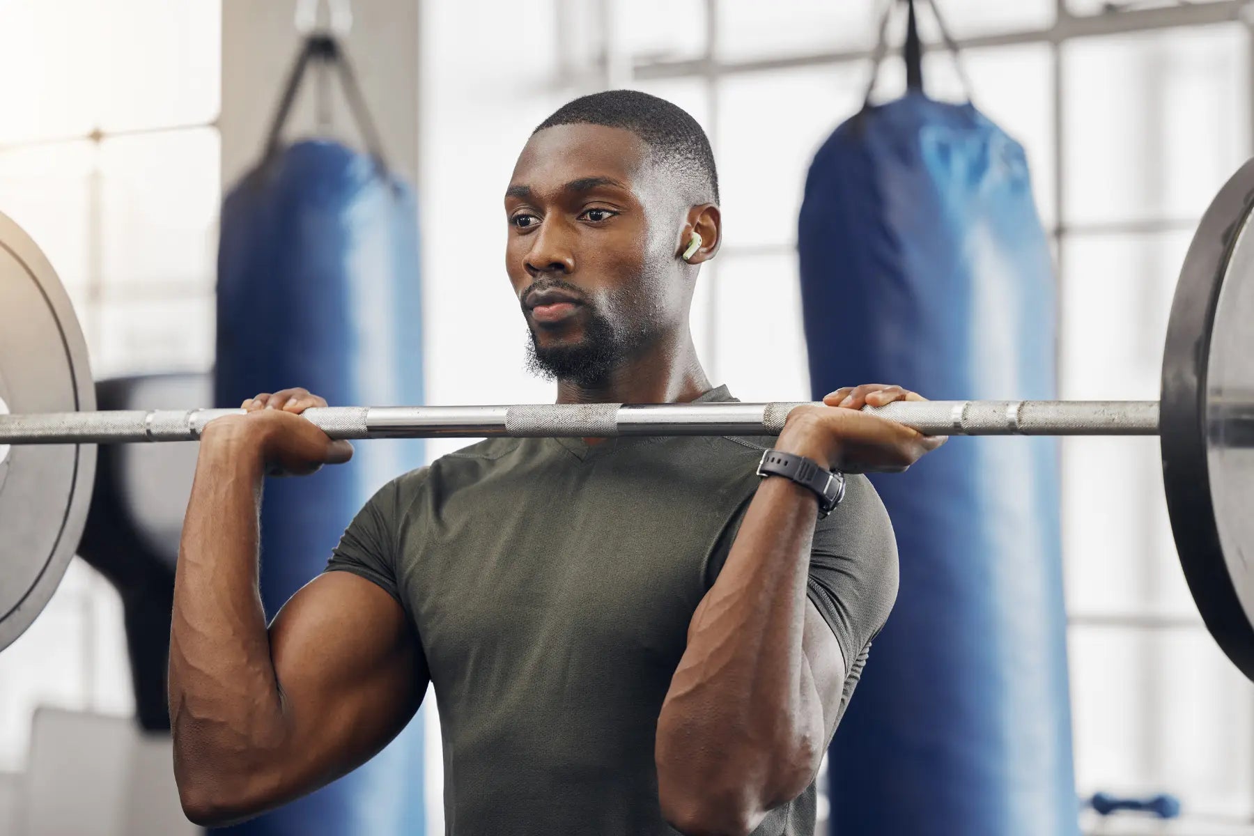 Early detection scanning helps track body composition changes, as shown by a man lifting weights in a gym.