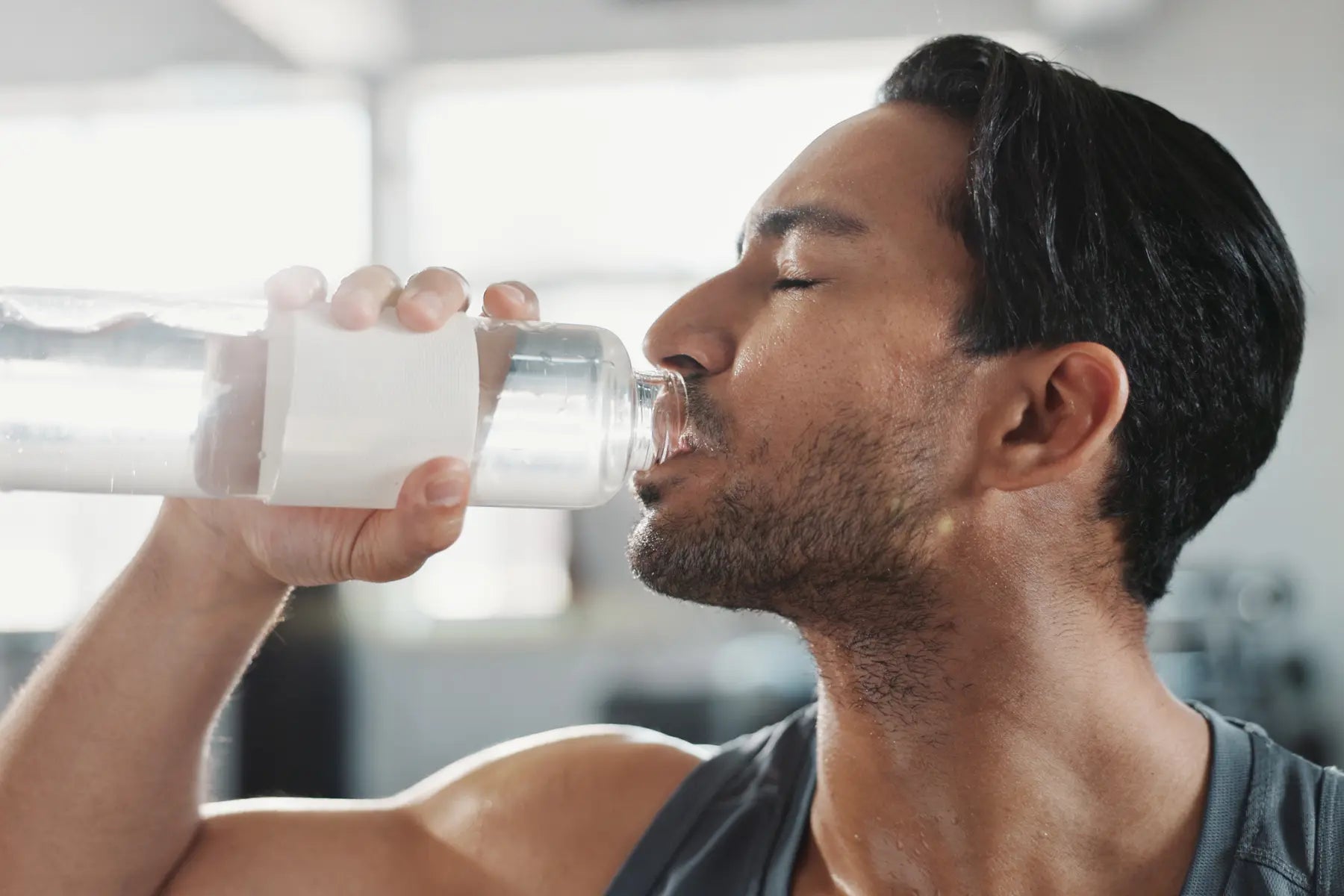 Gut health hydration shown by a man drinking water after exercise to support digestion and overall wellness.
