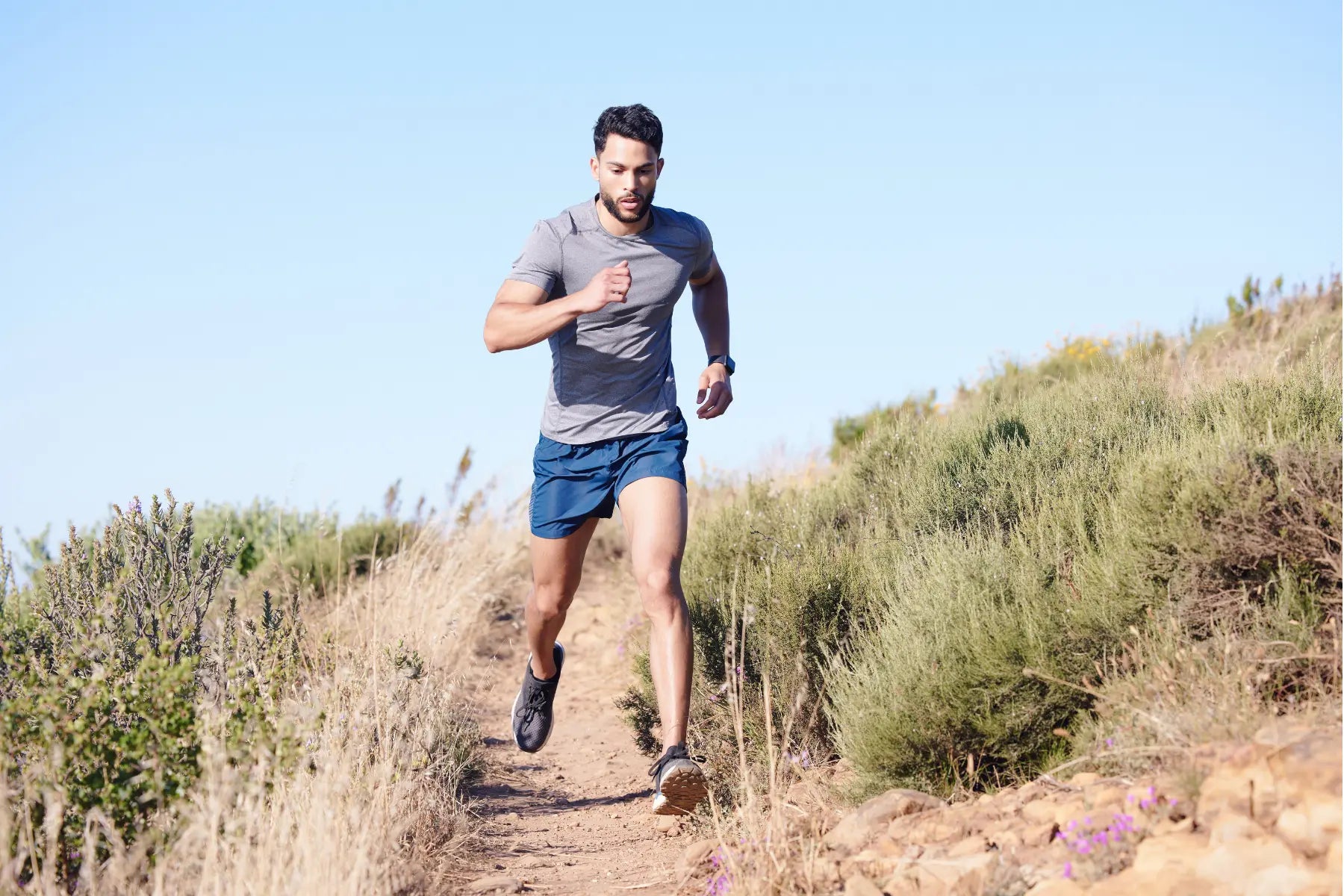 Improve VO2 max running with a man sprinting uphill on a trail to boost cardiovascular endurance.