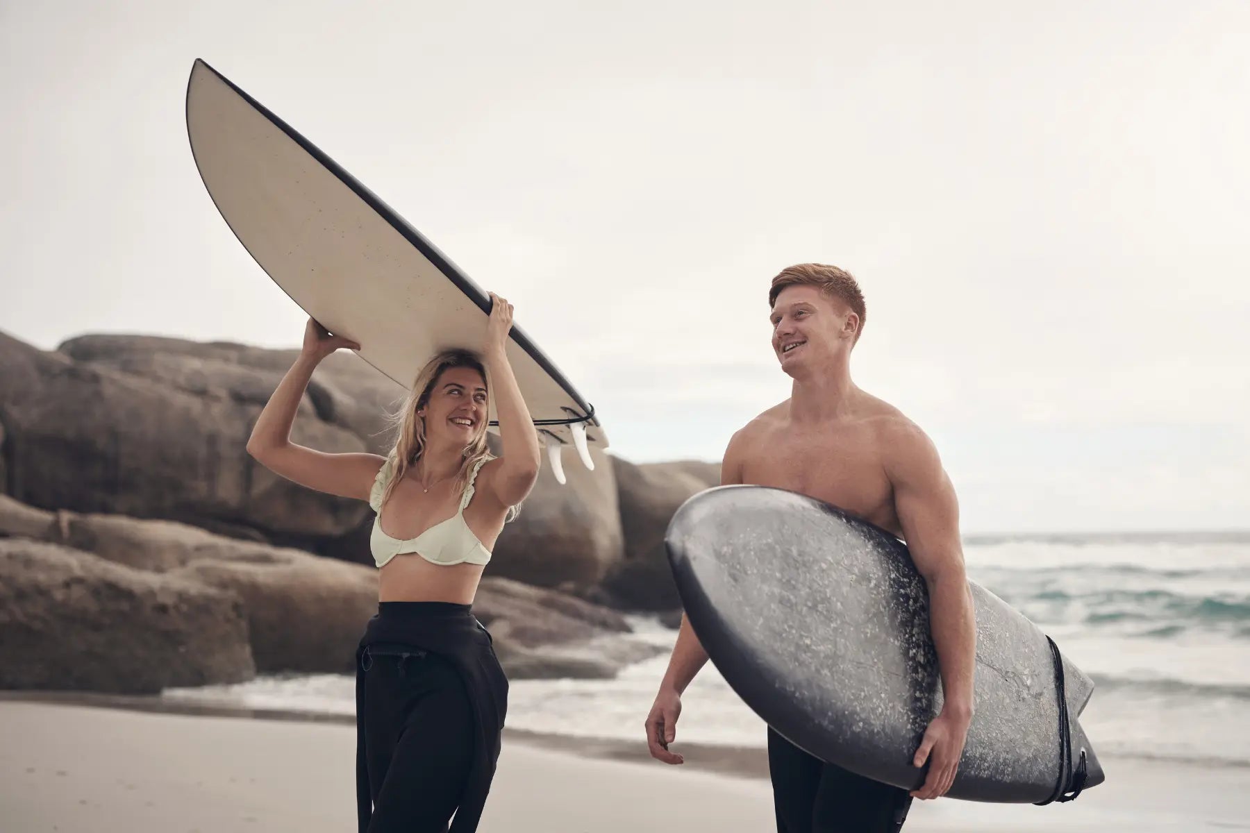 Musculoskeletal scans benefit surfers, captured walking with surfboards after a session.
