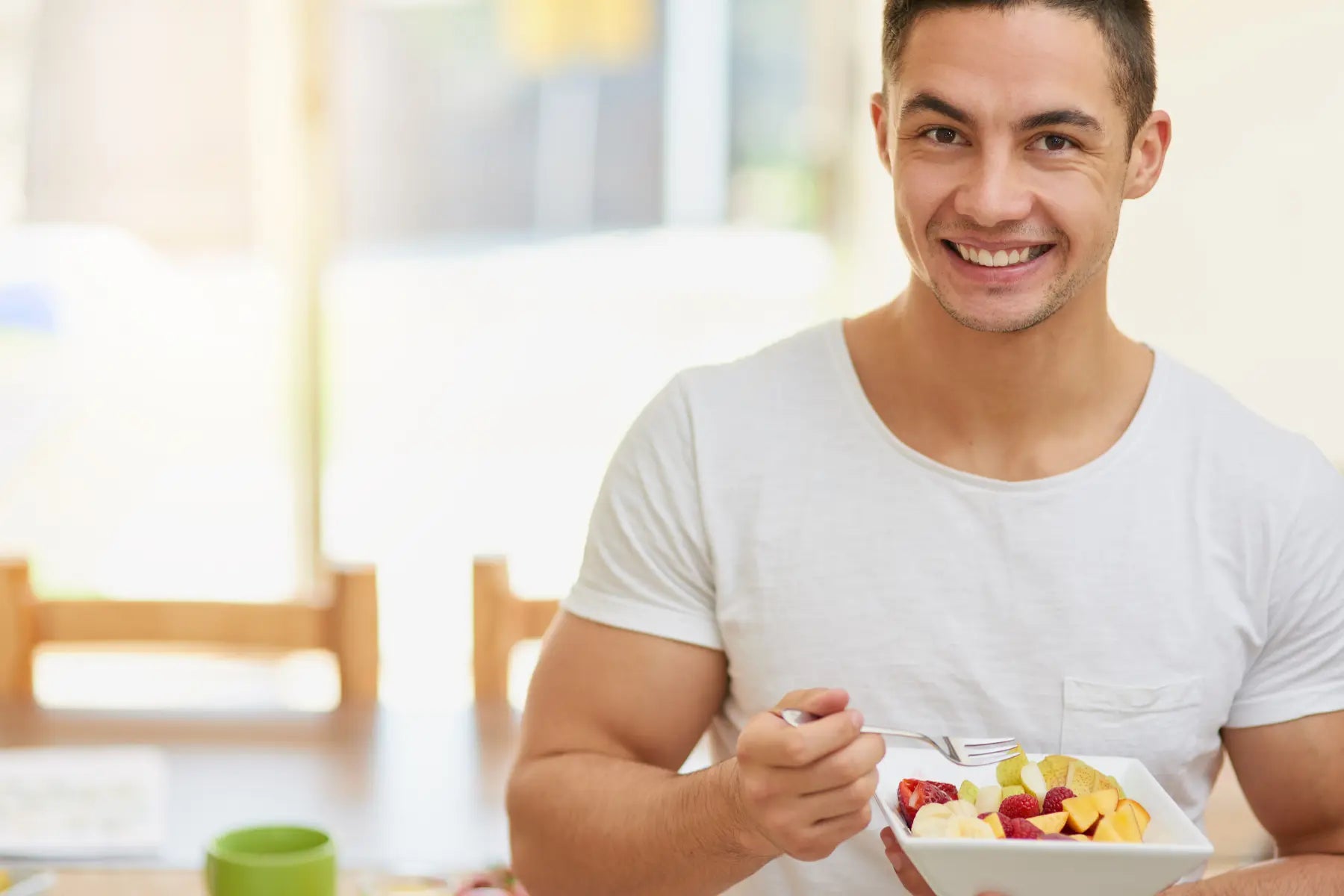 Pylori blood test preparation includes healthy eating habits, shown by a man smiling while eating a fruit bowl.