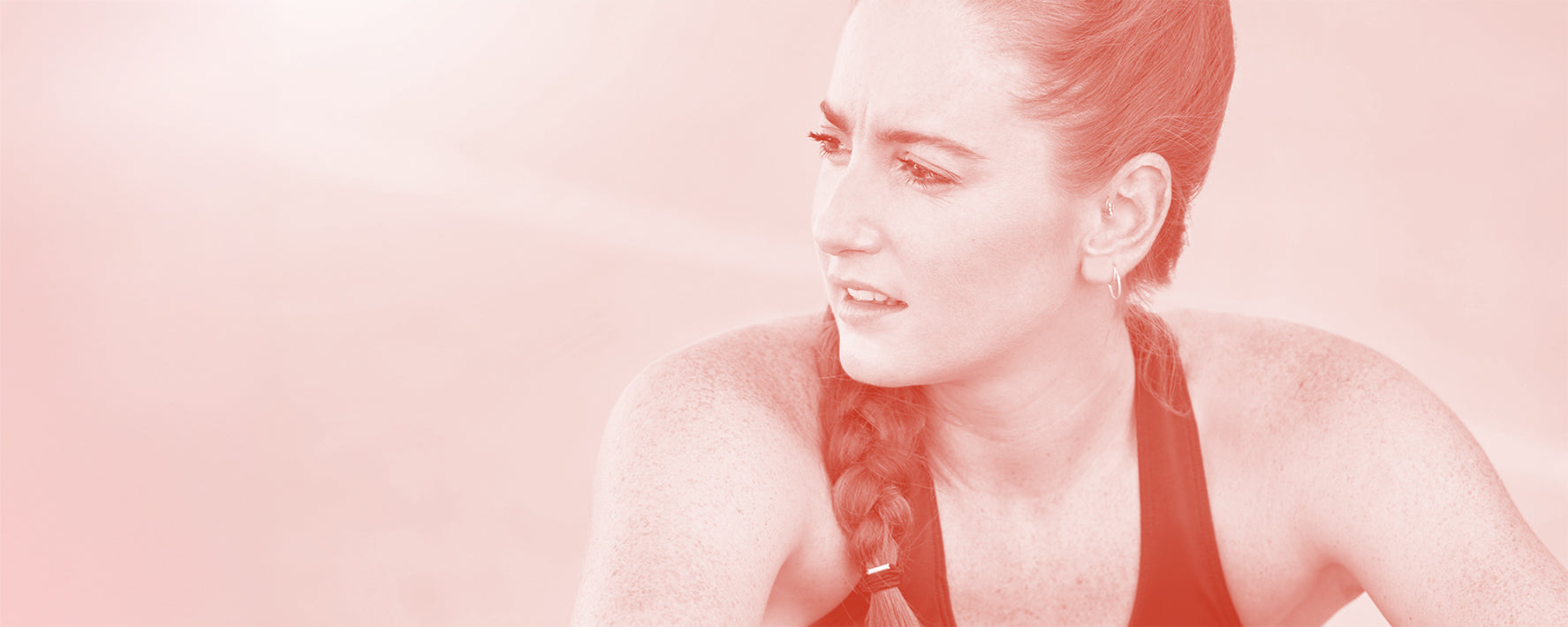 Woman with braided hair against a pink background