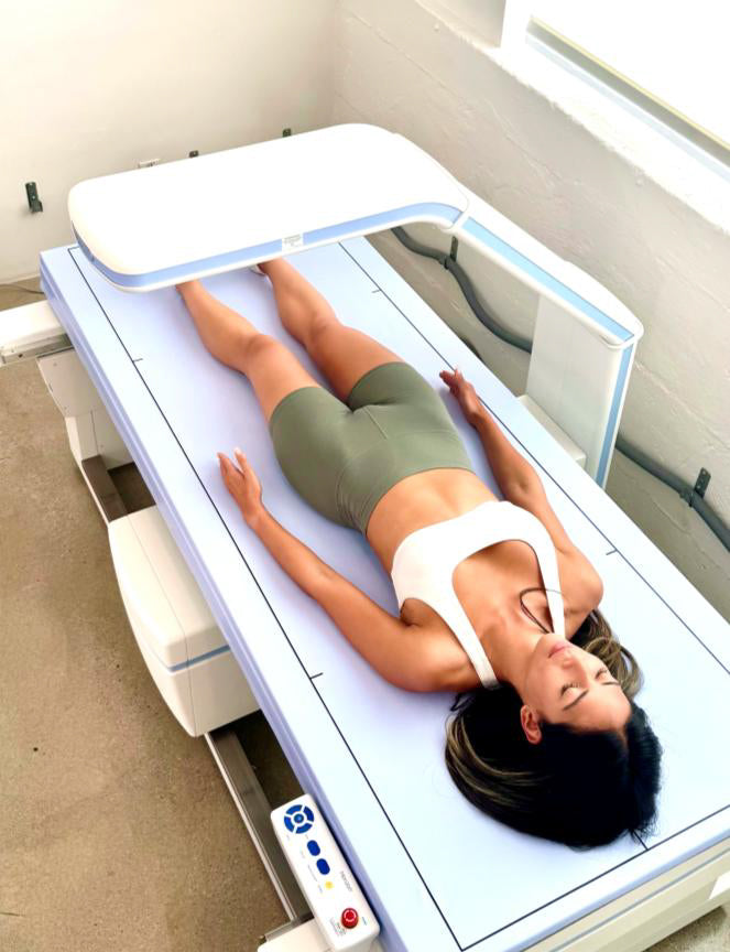 Woman lying on a DEXA scan table with a light box above her in Venice, CA