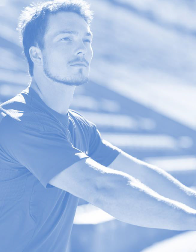 Man with a beard and short hair wearing a polo shirt, standing against a blurred background.