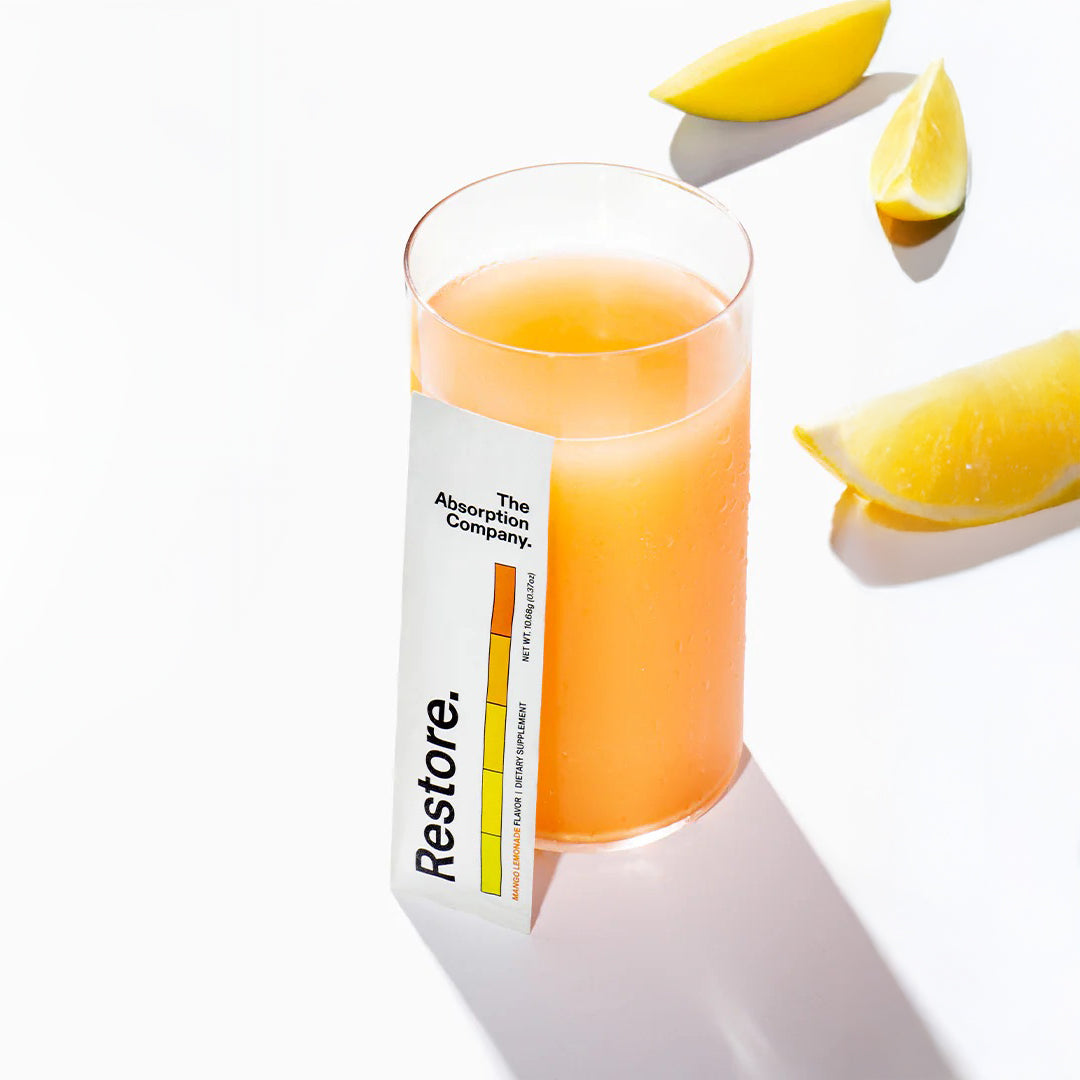 Glass of orange juice with a 'Restore' label on a white background